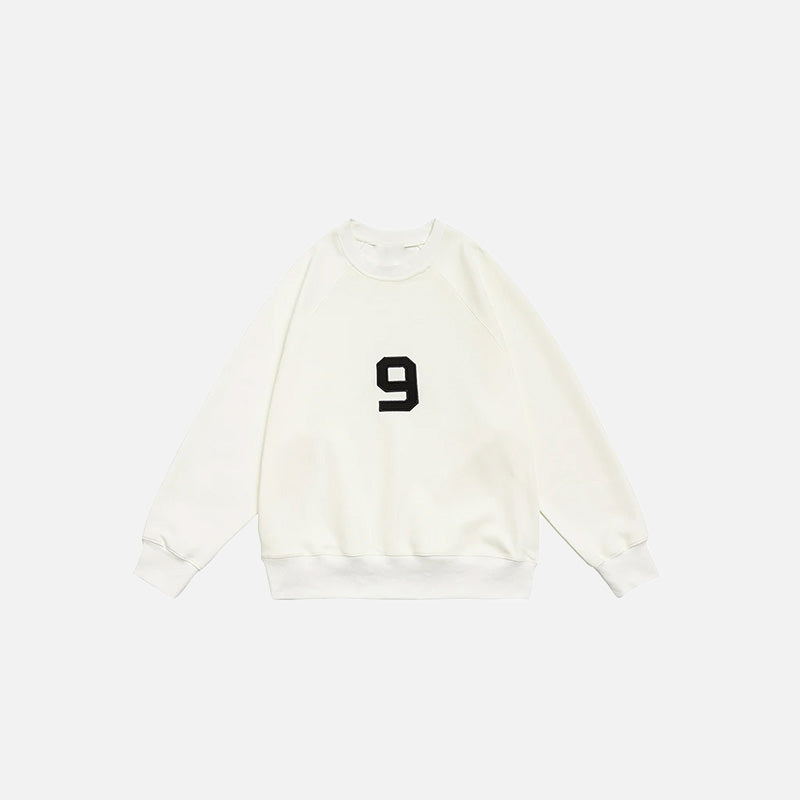 Front view of the beige Number 9 Embroidered Sweatshirt in a gray background