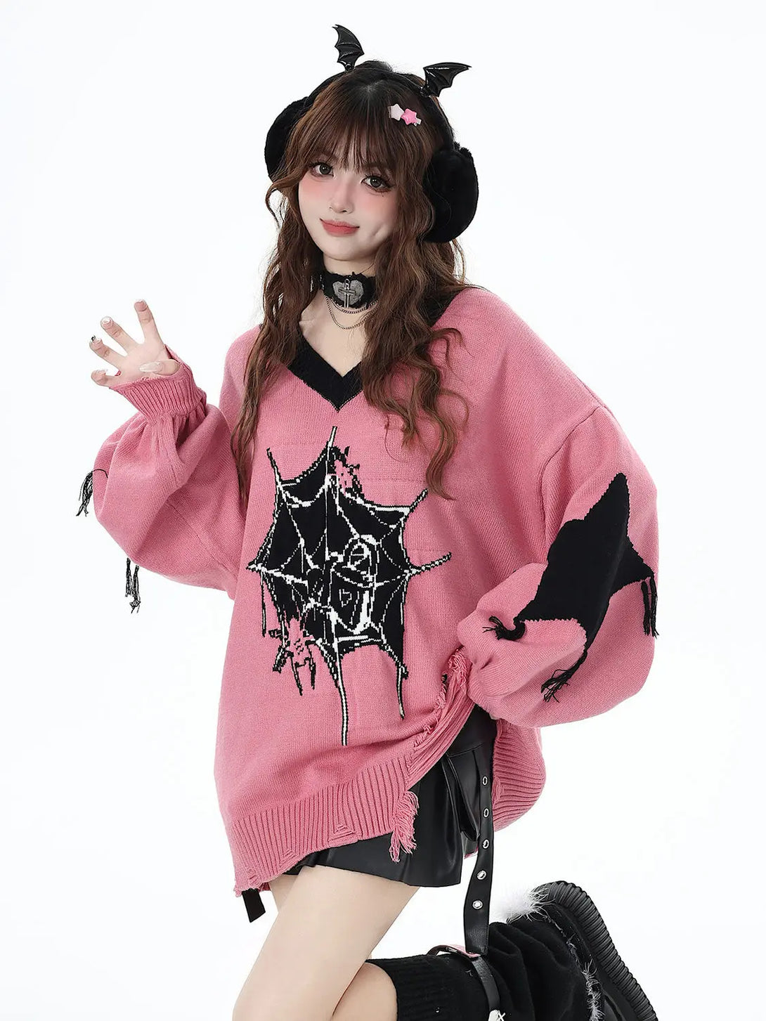 Model wearing the pink Spider Embrace Knit Sweater in a white background