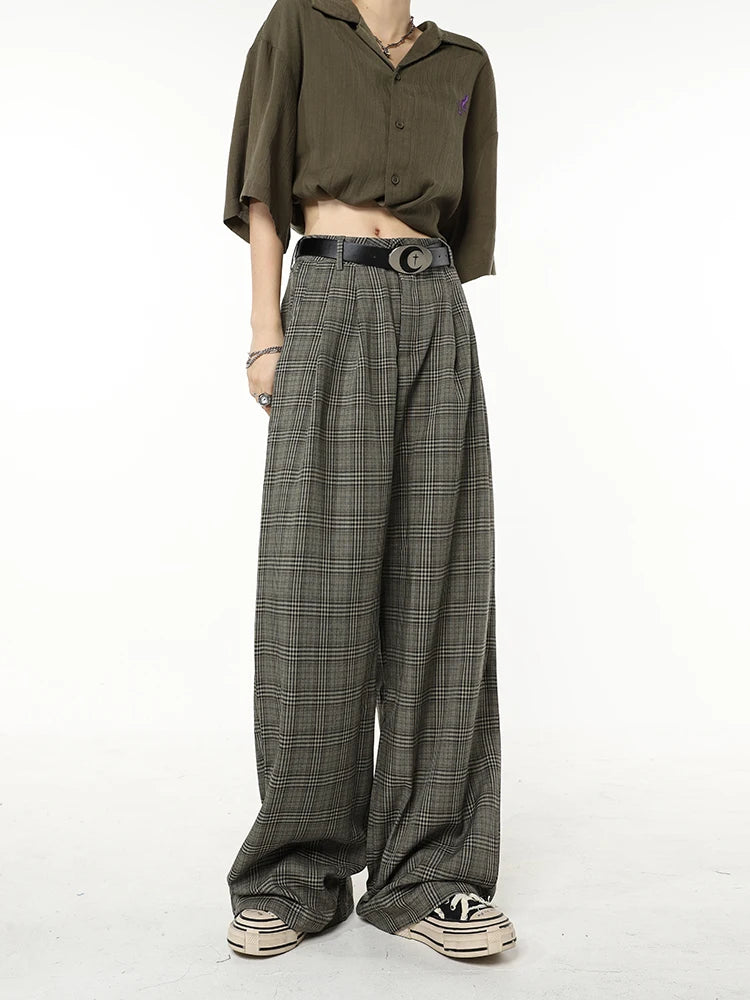 Model wearing the dark grey Vintage Plaid Wide-Leg Jeans in a gray background