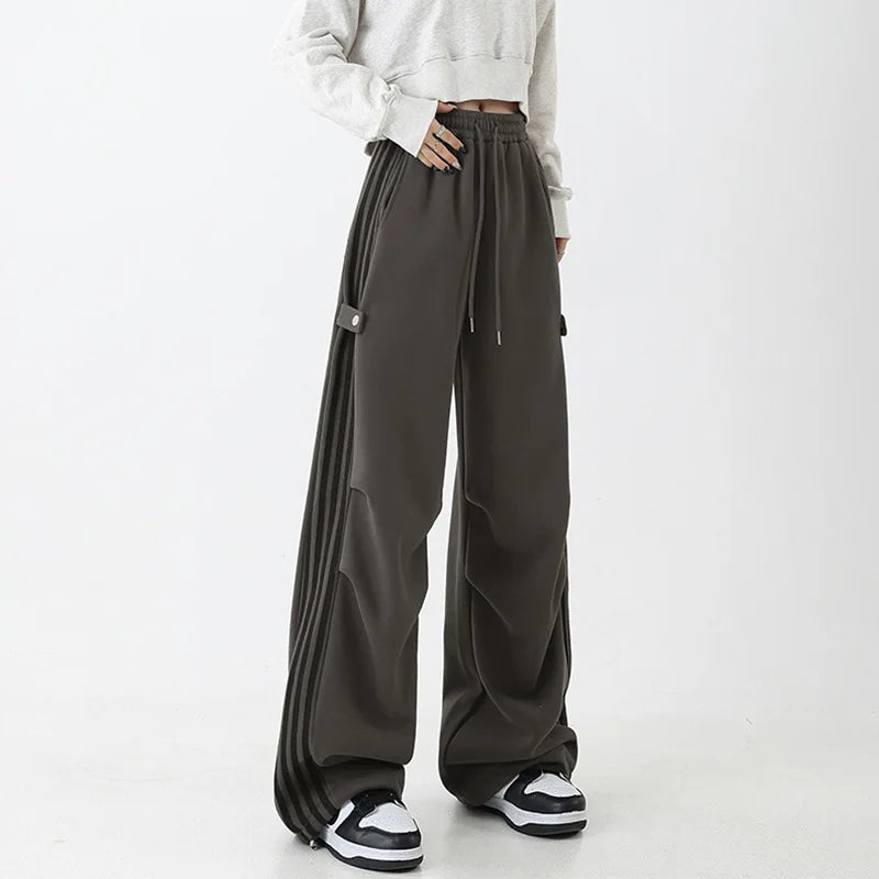 Model wearng the grey Wide-Leg Track Pants in a gray background