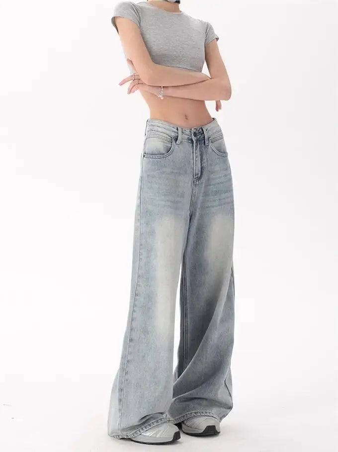 Model wearing the blue Oversized Denim Flares Jeans in a gray background