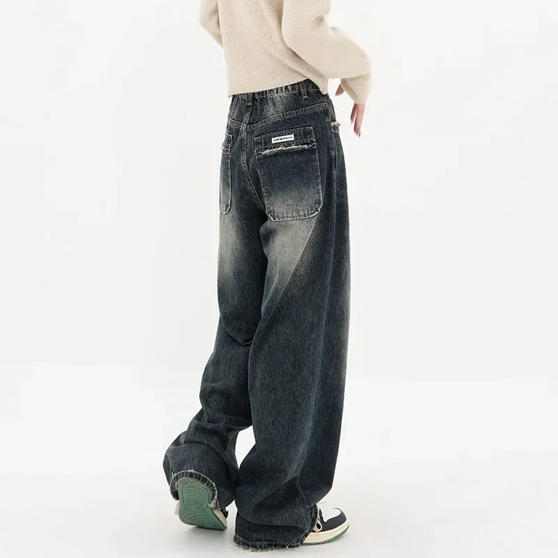 Model wearing the deep blue Stone Wide-Leg Jeans in a gray background