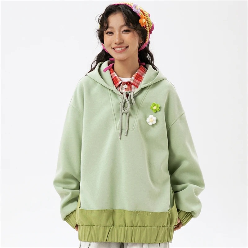 Model wearing the green Women's Blossom Charms Hoodie in a gray background