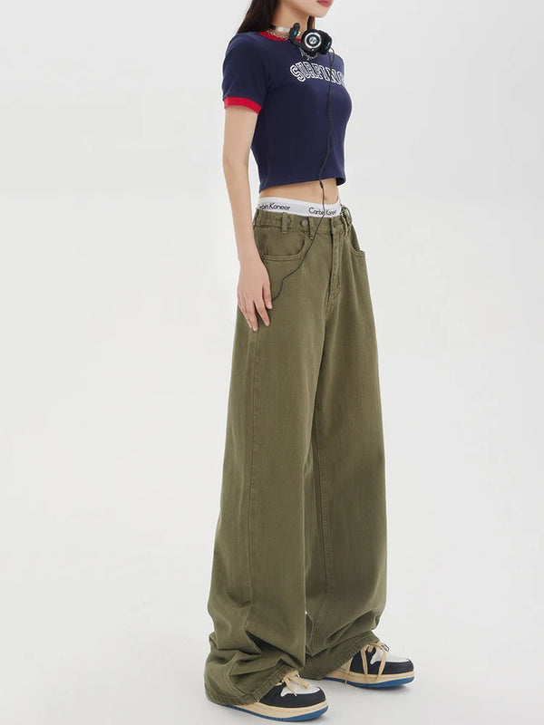 Model wearing the Baggy Olive Green Wide-Leg Jeans in a gray background