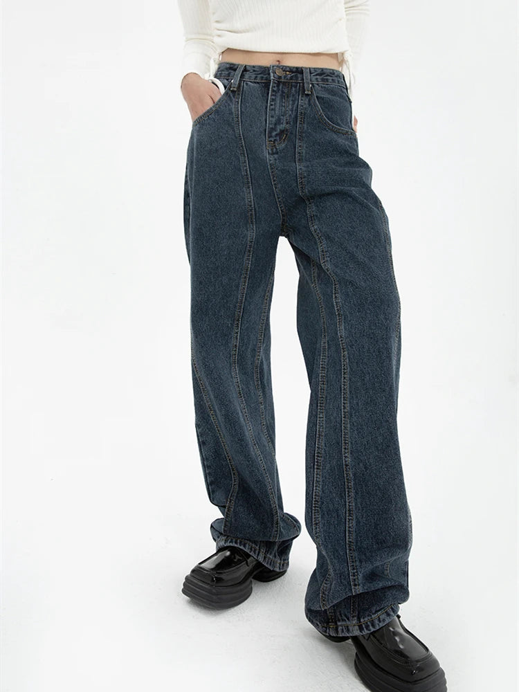 Model wearing the blue Vintage High-Rise Denim Jeans in a gray background