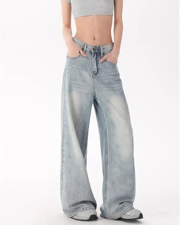 Model wearing the blue Oversized Denim Flares Jeans in a gray background