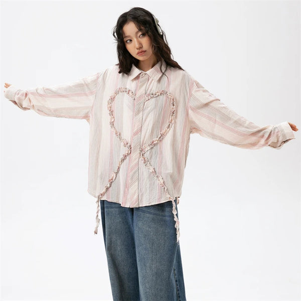 Model wearing the pink Heart Embroidery Long Sleeve Shirt in a gray background 