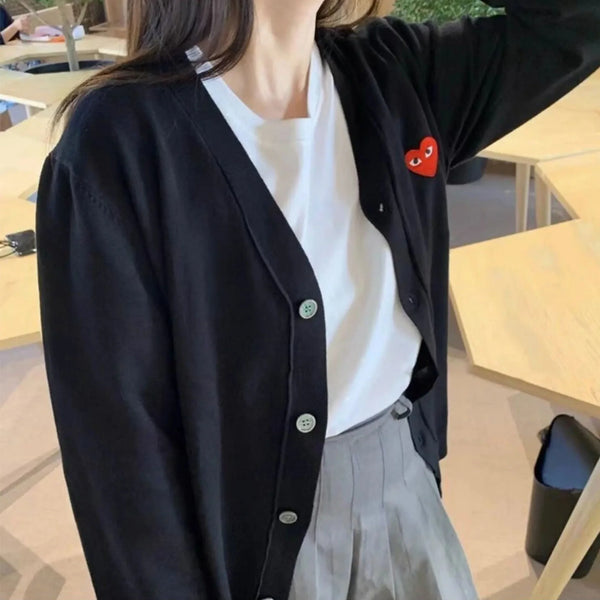 Model wearing the black Heart Patch Button-Up Sweater