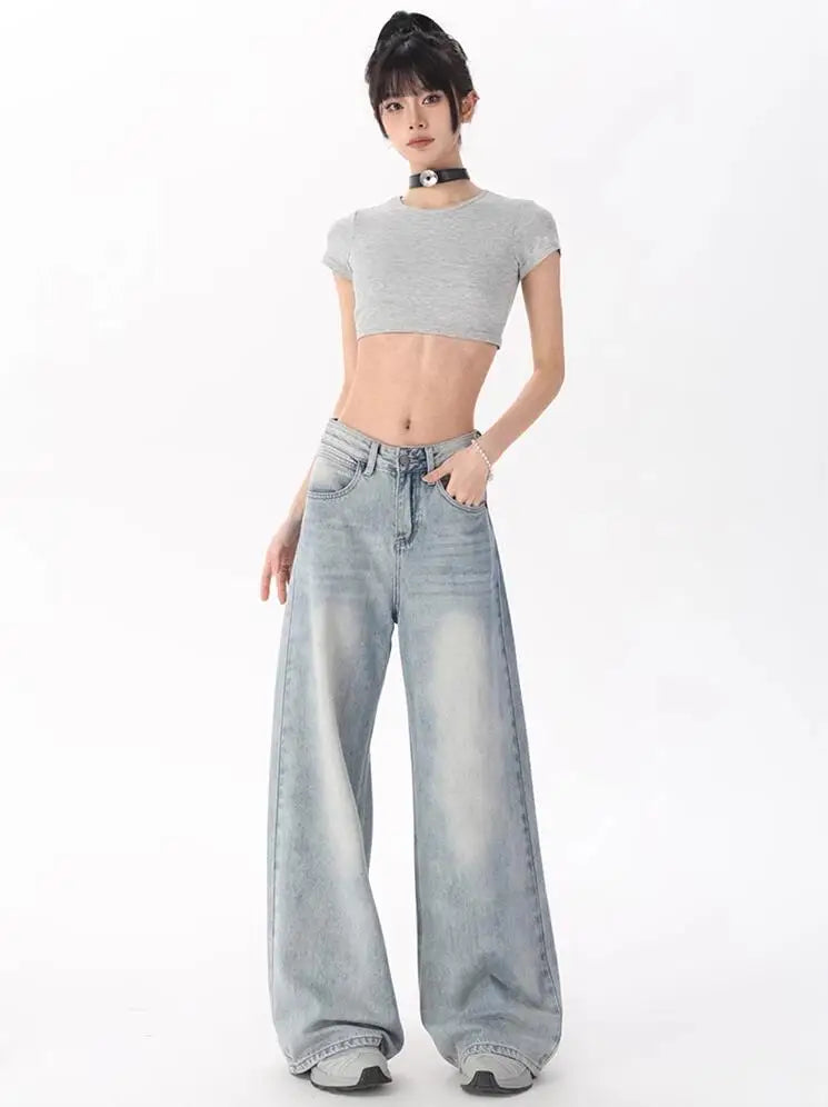 Model wearing the blue Oversized Denim Flares Jeans in a gray background