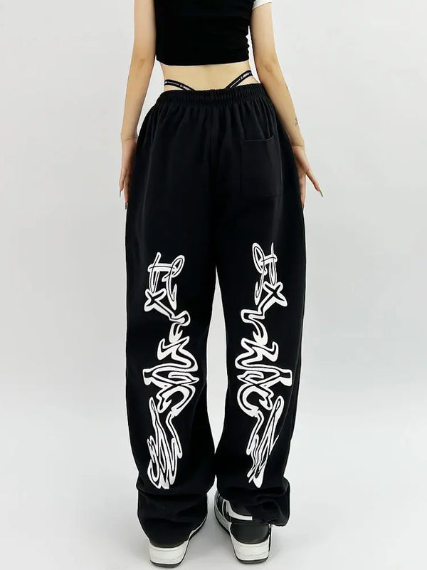 Model wearing the black Y2K Loose Graphic Sweatpants in a gray background