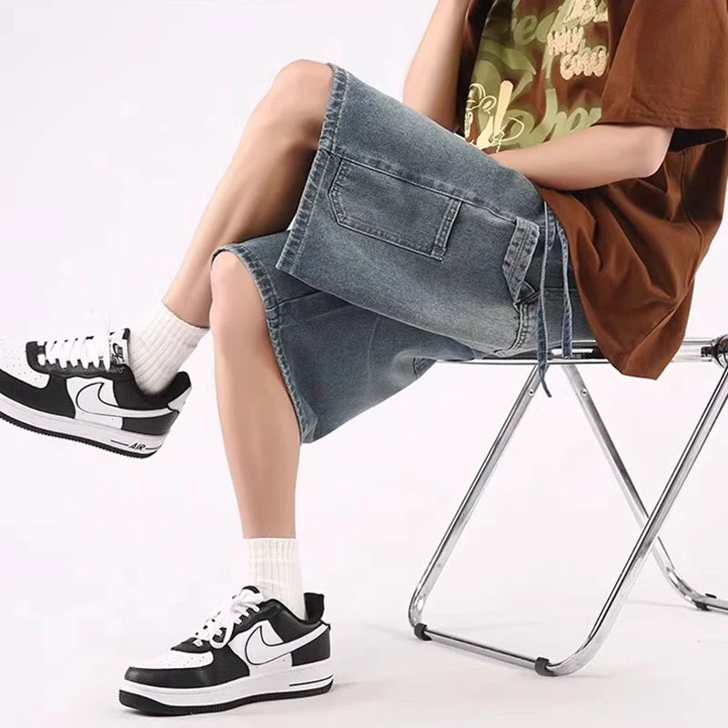 A model sitting while wearing the dark blue Baggy High Blue Denim Jorts from DAXUEN