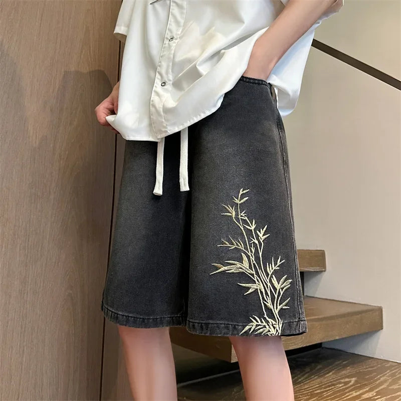 Model wearing the black Baggy Embroidered Denim Bermuda Shorts 