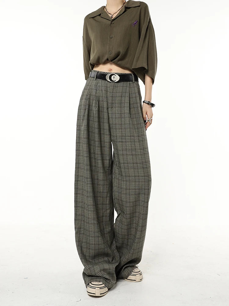 Model wearing the dark grey Vintage Plaid Wide-Leg Jeans in a gray background