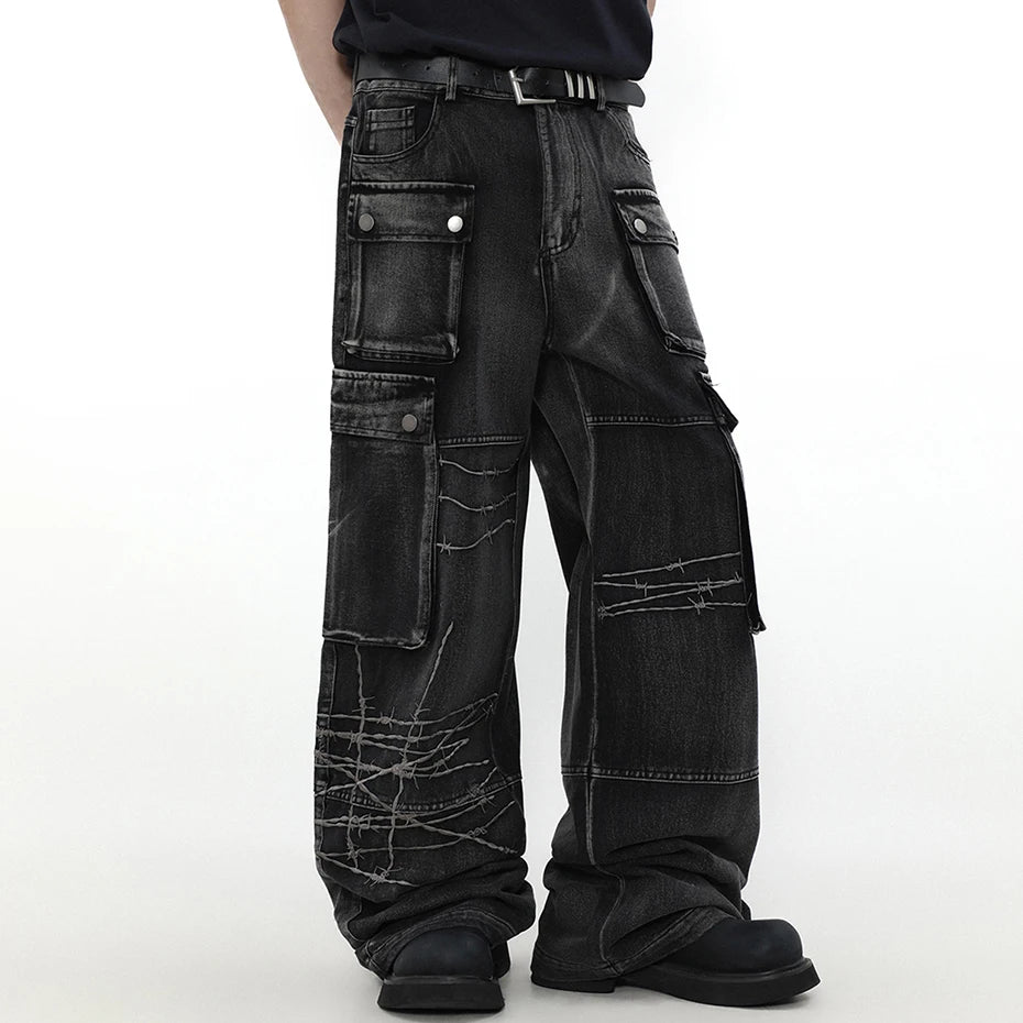 Model wearing the black Graffiti Patch Cargo Pants in a gray background