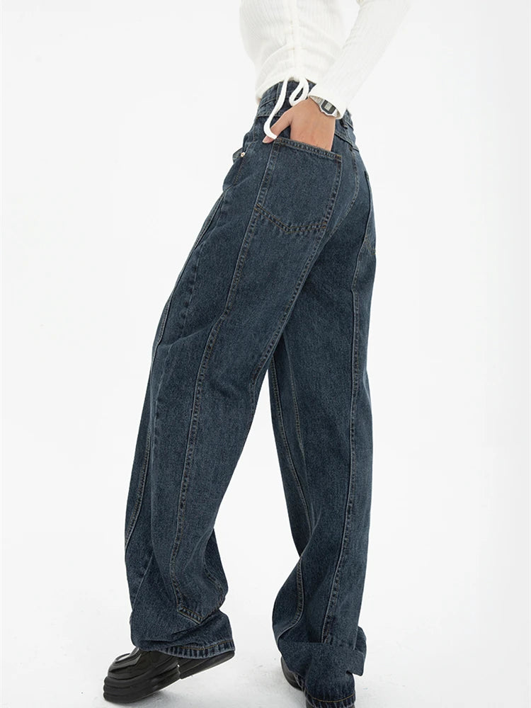 Model wearing the blue Vintage High-Rise Denim Jeans in a gray background