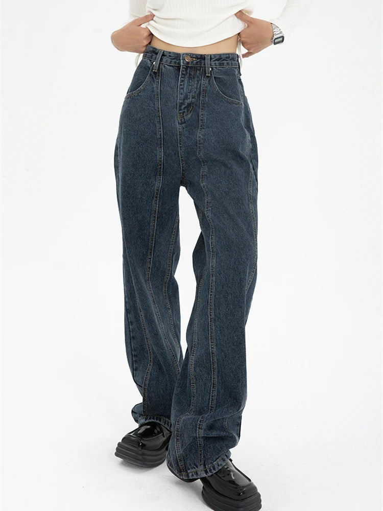 Model wearing the blue Vintage High-Rise Denim Jeans in a gray background