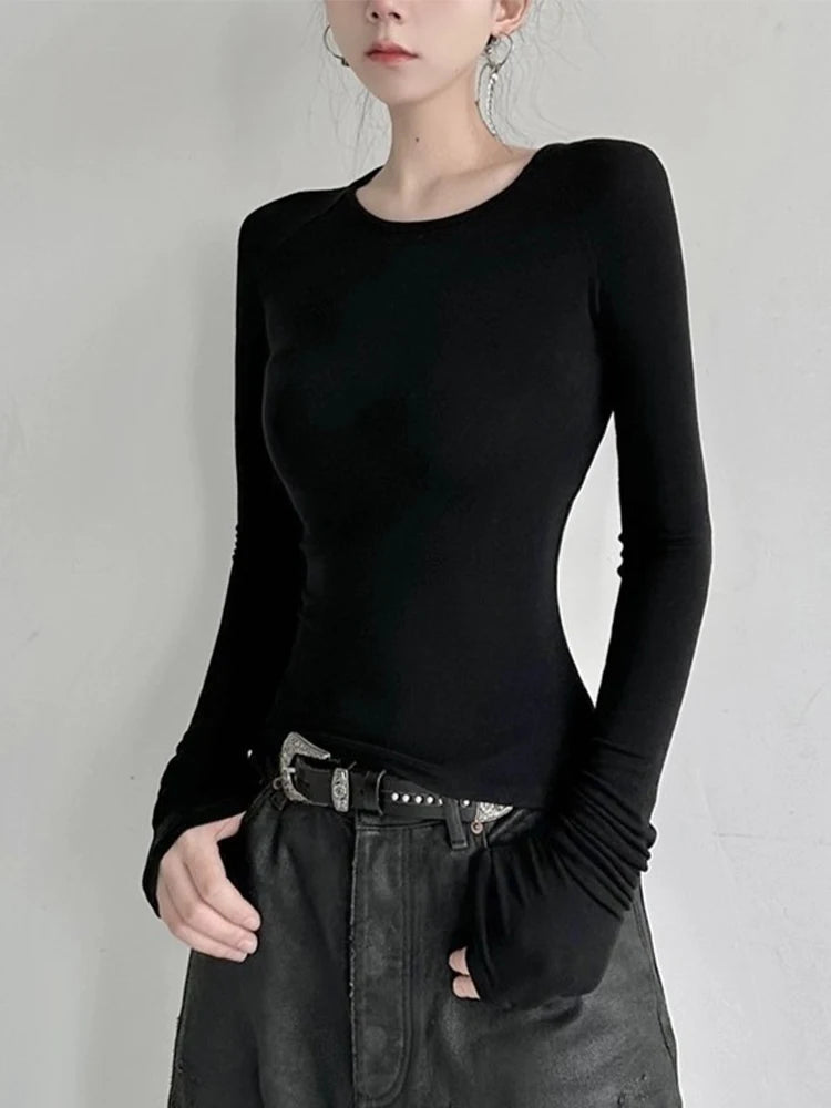 Model wearing the black Sleek Long-Sleeve Fitted T-shirt in a gray background