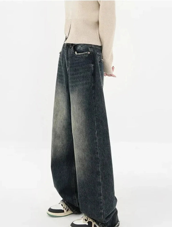 Model wearing the deep blue Stone Wide-Leg Jeans in a gray background