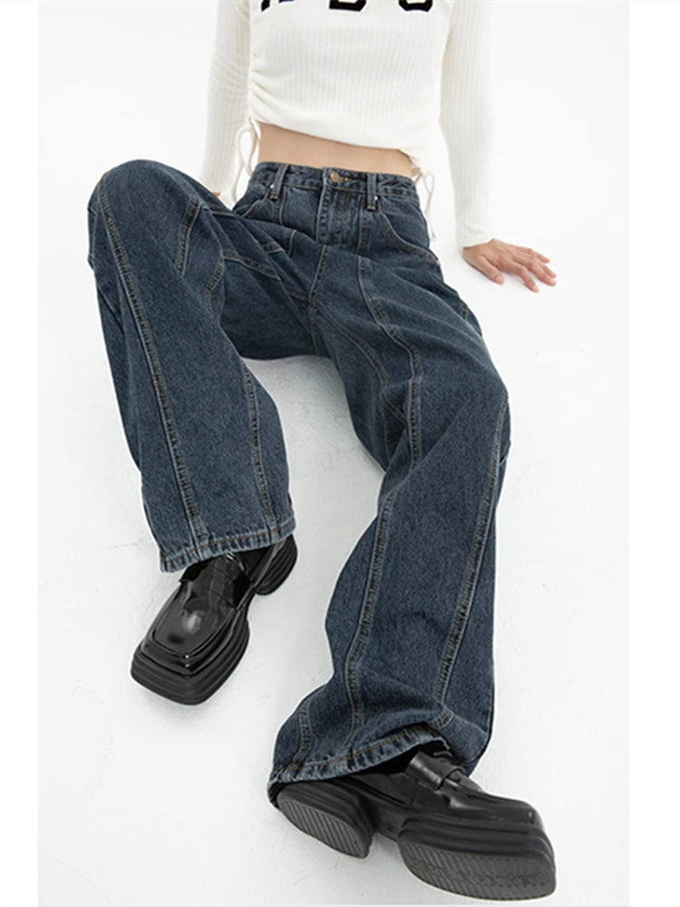 Model wearing the blue Vintage High-Rise Denim Jeans in a gray background