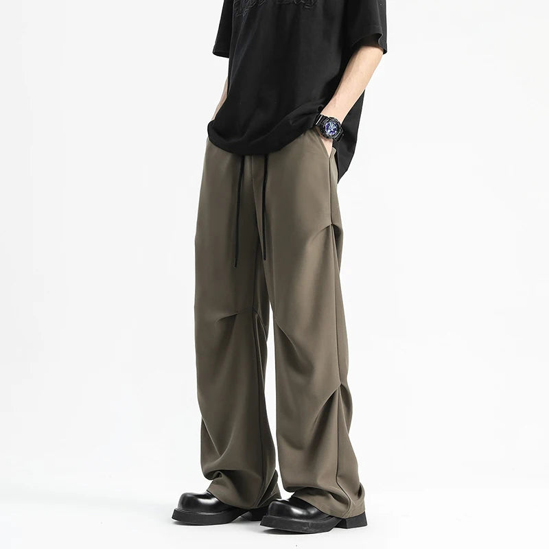 Model wearing the coffee Functional Side Flaps Cargo Pants in a gray background