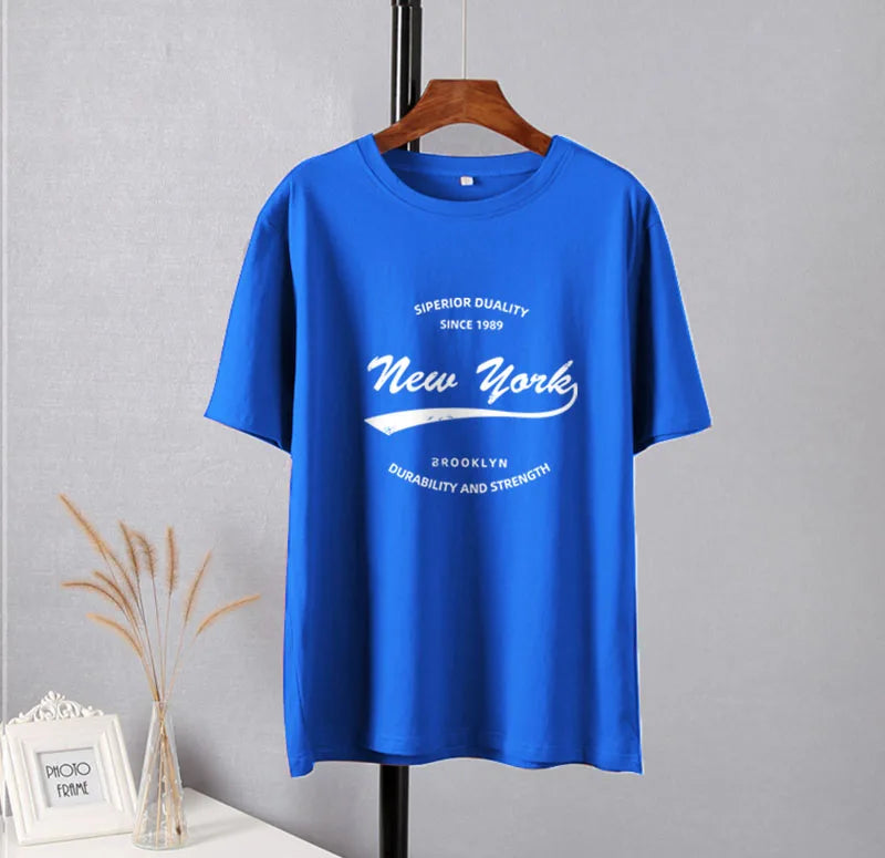 Front view of the blue Vibrant New York Graphic T-shirt in a gray background