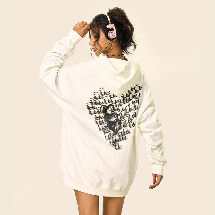 Model wearing the white Loose Cursive Love Heart Hoodie in a gray background 