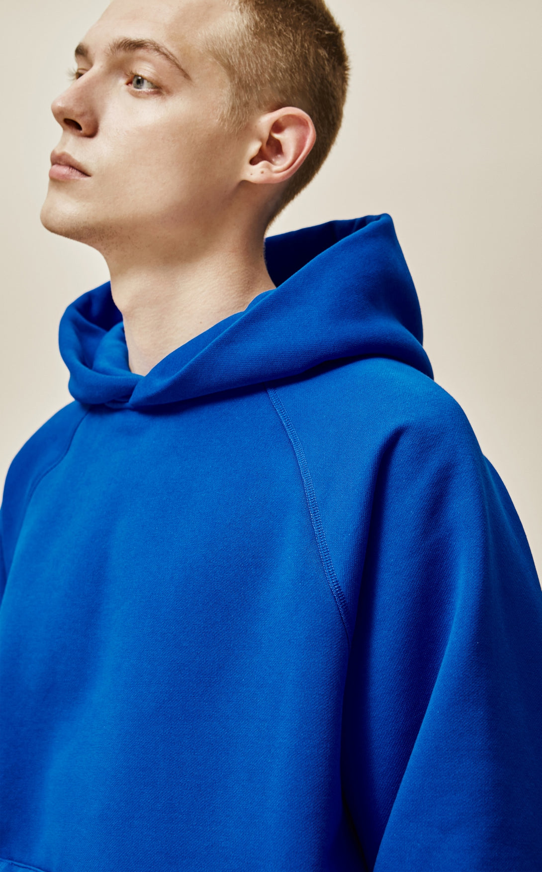 A guy wearing blue explorer hoodie side view