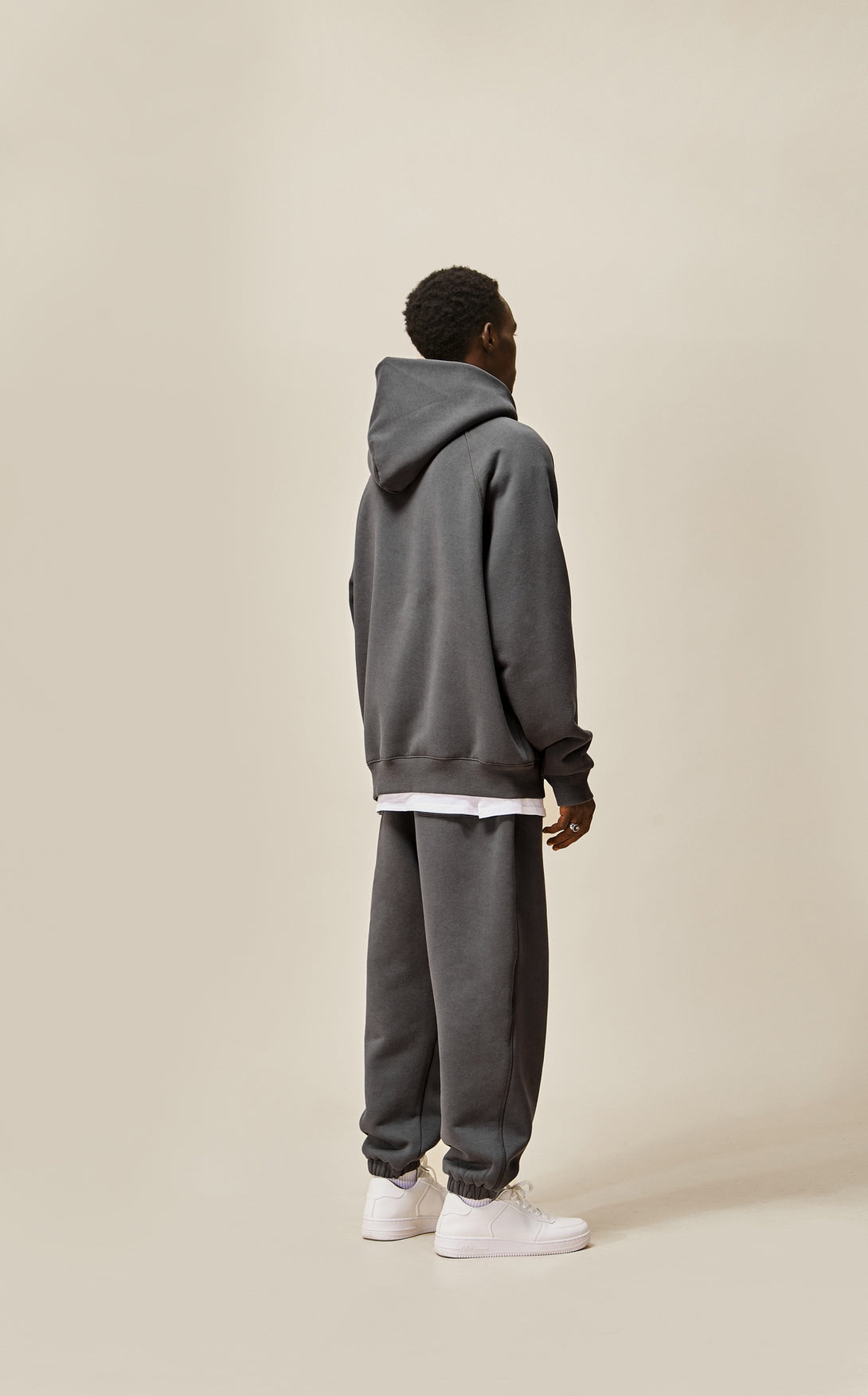 A guy wearing dark grey explorer tracksuit back view