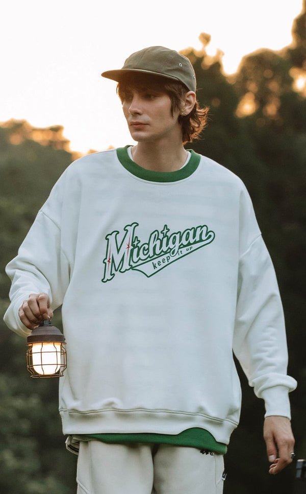 A guy carrying a lamb and wearing Michigan Sweatshirt